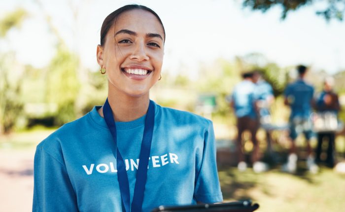 woman, happy and portrait of volunteer in nature with community service, ngo or donation project. smile, confident and female charity worker with confidence outdoor in field for social activism.